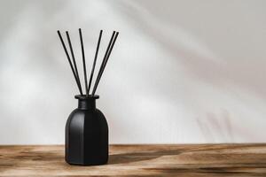 Black Reed Diffuser on a Wooden Table With Soft Light Casting Shadows photo