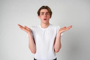 Young Man With Surprised Expression and Hands Raised in Studio Setting photo
