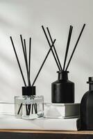 Aromatic Reed Diffuser on White Books With Shadows Playing on the Wall photo