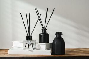 Aromatic Reed Diffuser on White Books With Shadows Playing on the Wall photo