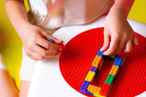 Child Engaged in Creative Play With Colorful Building Blocks on a Round Base photo