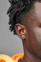 Close-Up View of African Mans Hair and Ear Against a Grey Background photo