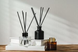 Aromatic Reed Diffuser on White Books With Shadows Playing on the Wall photo