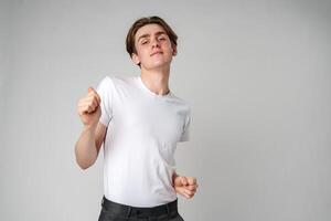 Young Man in Casual Attire Dancing Alone in a Studio Setting photo