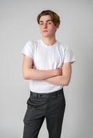 Young Man With Arms Crossed Standing Against a Plain Background in a Studio photo