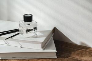 Aromatic Reed Diffuser on White Books With Shadows Playing on the Wall photo
