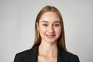 Young Woman in Black Jacket Posing to Camera against gray background photo