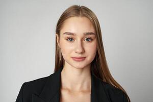 Young Woman in Black Jacket Posing to Camera against gray background photo