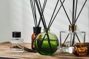 A Collection of Aromatic Reed Diffusers on a Wooden Table Against a Neutral Background photo