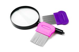 A magnifying glass and lice comb placed side by side on a clean white background photo