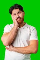 A man with a serious expression stands against a vibrant green background photo