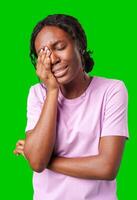 Woman expressing frustration while standing against a bright green background photo