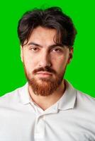 A man with a serious expression stands against a vibrant green background photo