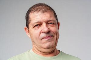 Middle-aged man with a thoughtful expression against a plain background photo