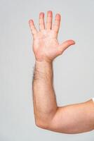 Hand raised in greeting against a plain background photo