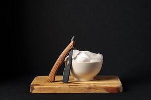 Classic Shaving Equipment With Razor, Brush, and Soap on Wooden Stand Against Dark Background photo