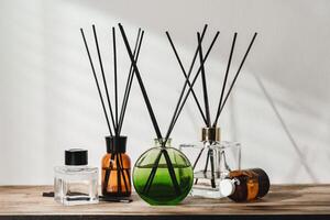 A Collection of Aromatic Reed Diffusers on a Wooden Table Against a Neutral Background photo