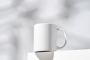 One white mug on gray background with shadow photo