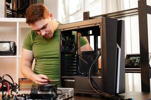 Man assembles a computer system unit at home photo