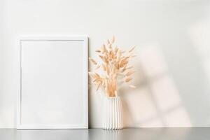 Blank picture frame and dried flower in a vase on white background photo