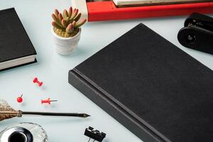 Notebook and feather pen on working table photo