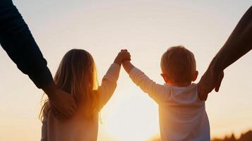 A family enjoys a beautiful sunset while holding hands at a tranquil outdoor location during evening hours photo