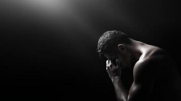 A contemplative man in a dimly lit space reflects on personal challenges and emotions in a moment of solitude and introspection photo