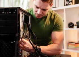 Man assembles a computer system unit at home photo