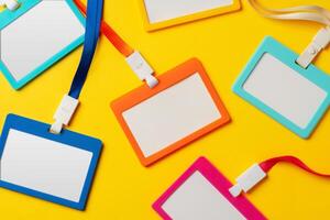 Colored blank nametags on strings on yellow background photo