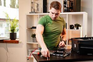 Man assembles a computer system unit at home photo