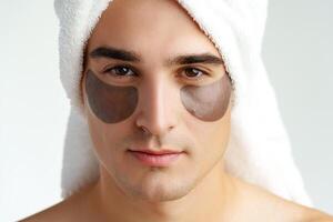 Portrait of attractive young male model with eye patches on white background photo