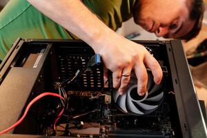 Man assembles a computer system unit at home photo