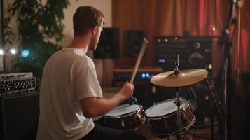A drummer playing energetically in a cozy recording studio during a late-night jam session photo