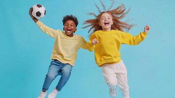 Kids having fun while jumping and playing with a soccer ball against a bright blue backdrop during a joyful moment of leisure photo