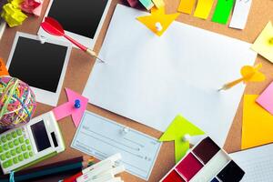 Desk of an artist with lots of stationery objects photo