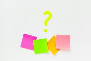 sticky notes with question marks over white photo