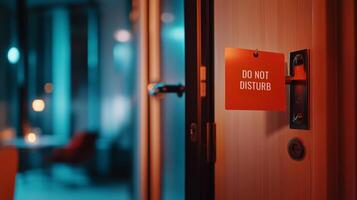 A hotel door with a 'Do Not Disturb' sign hangs outside an inviting, softly lit room during the evening photo