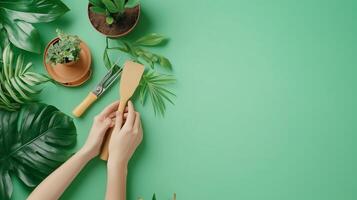 A person tending to indoor plants using a gardening tool on a bright green surface surrounded by leaves and pots photo