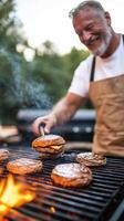 An enthusiastic man grills delicious burgers over an open flame during a summer barbecue gathering in a backyard setting photo