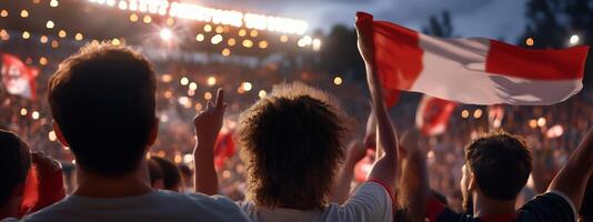 Crowd celebrating with flags during a nighttime sports event at the stadium, creating a vibrant atmosphere of excitement and team spirit photo