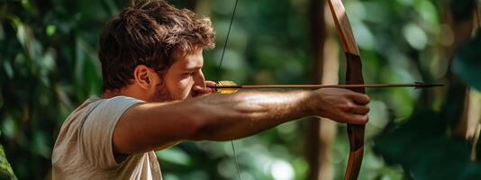 A young man focuses intently as he draws back a bowstring while practicing archery in a lush green forest setting photo