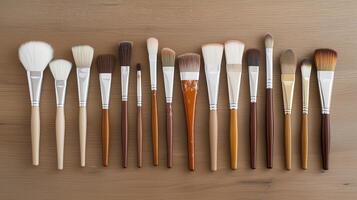 Various makeup brushes arranged neatly on a wooden surface showcasing different sizes, shapes, and bristle types for diverse beauty applications photo