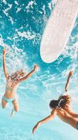 Two surfers diving into clear ocean water beneath a bright sunlit sky in a vibrant tropical setting photo