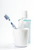 Toothbrushes in glass on table on light background photo