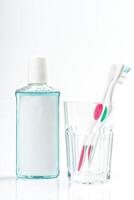 Toothbrushes in glass on table on light background photo