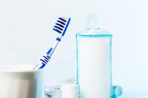 Toothbrushes in glass on table on light background photo