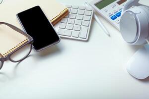 Office desk table with computer keyboard, supplies, calculator, pen, glasses photo
