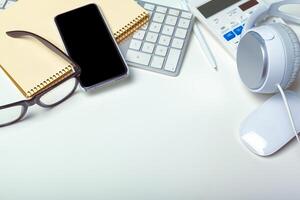 Office desk table with computer keyboard, supplies, calculator, pen, glasses photo