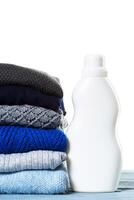 Stack of various sweaters isolated on white background photo