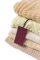 Stack of various sweaters isolated on white background photo